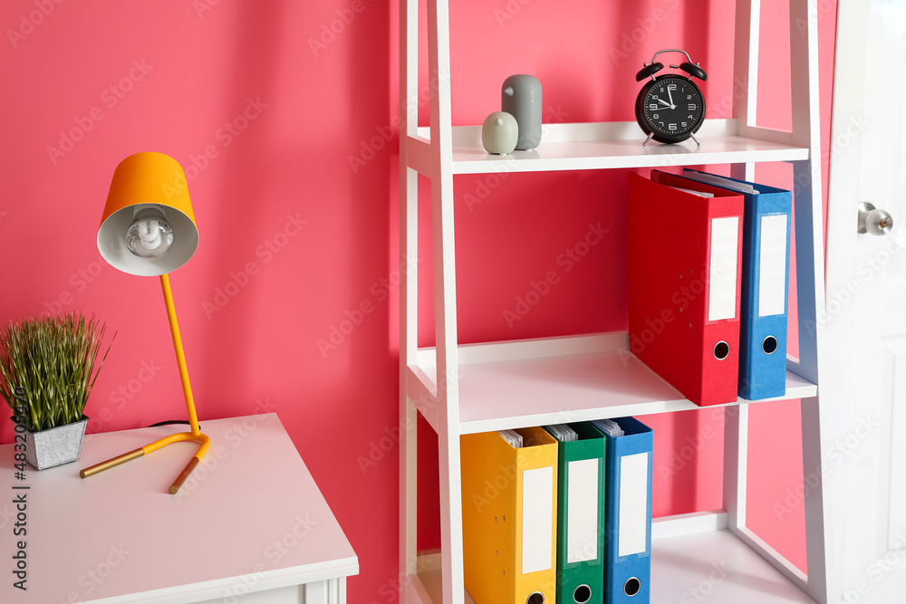 Shelf unit with folders near color wall