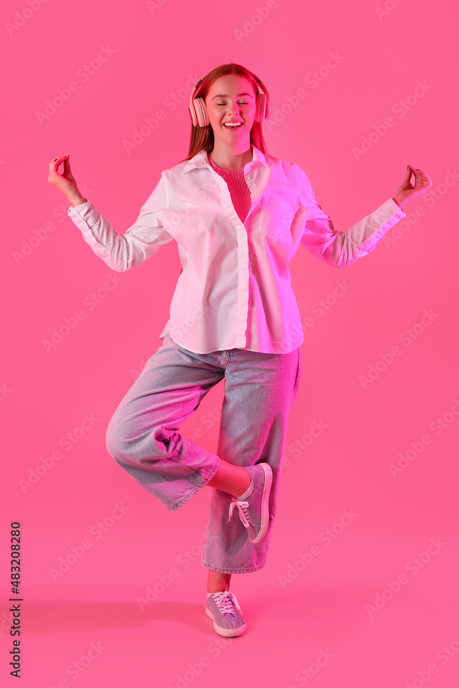 Young woman listening to music and meditating on color background