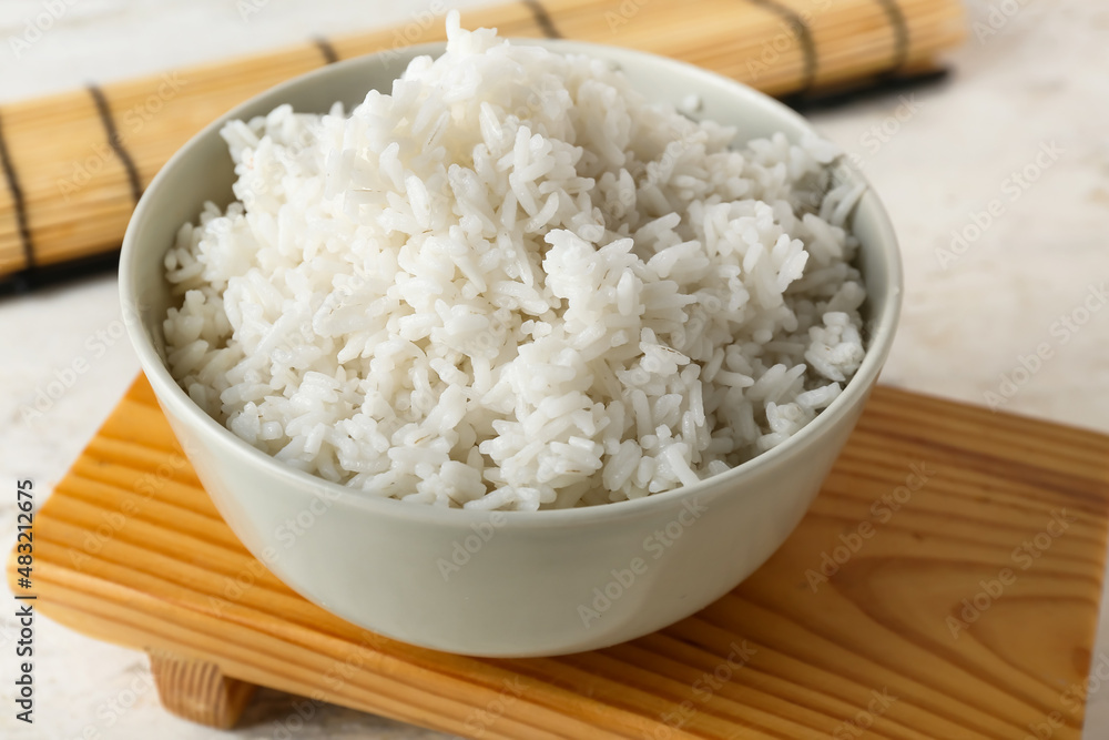 Bowl with tasty boiled rice on light background, closeup
