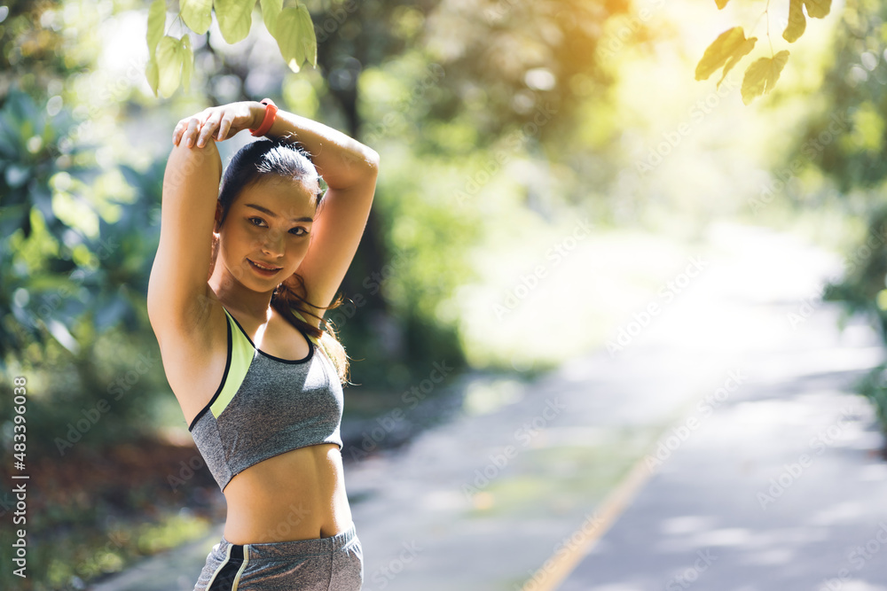 美丽的亚洲女孩在慢跑前伸展身体并热身。