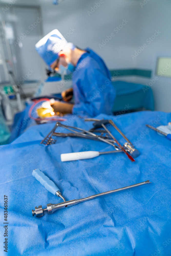 戴着特殊手术眼镜的外科医生提供手术。工具在第一计划中。仔细周到。