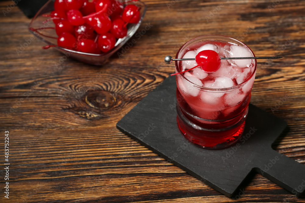 Glass of tasty Manhattan cocktail on wooden background