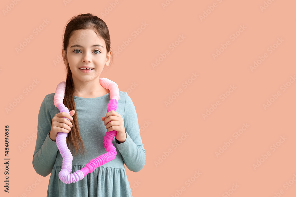 Funny little girl with Pop Tubes on pink background