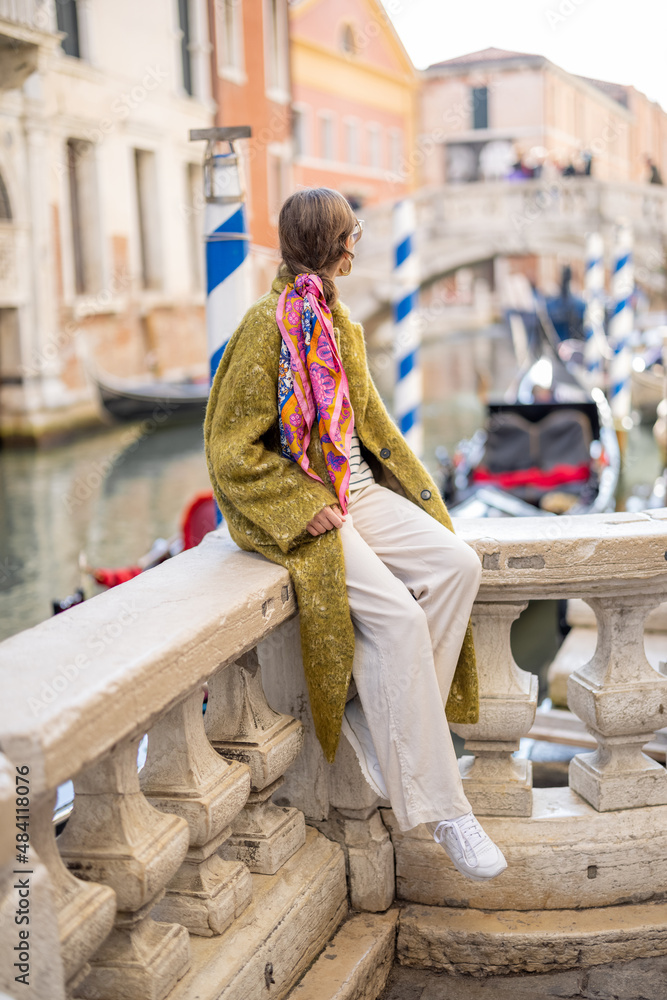 女人在威尼斯旅行时，坐在威尼斯运河上欣赏美景。女人wea