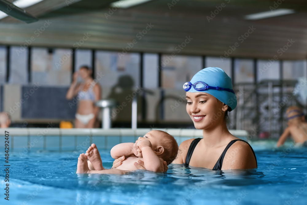 女教练教小婴儿如何在游泳池游泳