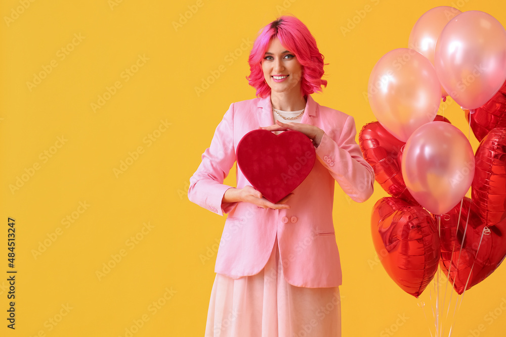 时髦的女人，有着明亮的头发，礼物和彩色背景的气球。情人节庆祝活动