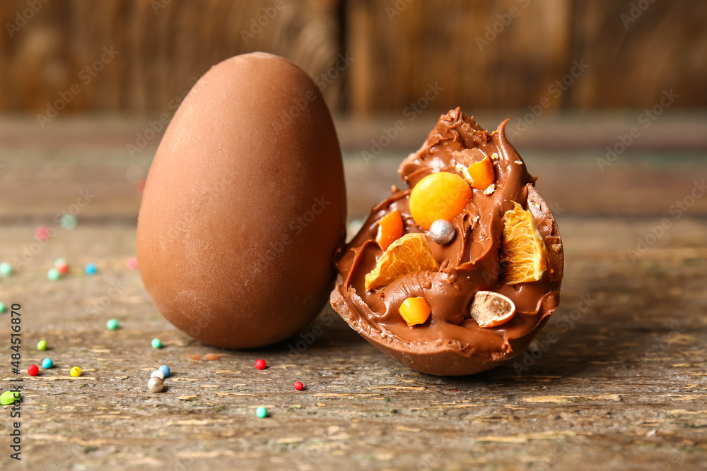 木制桌子上有不同糖果的碎巧克力复活节蛋，特写