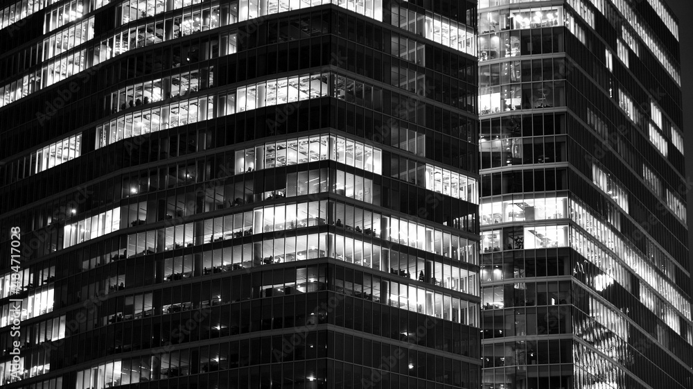 令人惊叹的城市夜景。夜间的办公楼，玻璃和灯光的建筑立面。用
1722638137,一个拿着笔记本电脑坐在地板上的年轻女人惊讶地指着一边