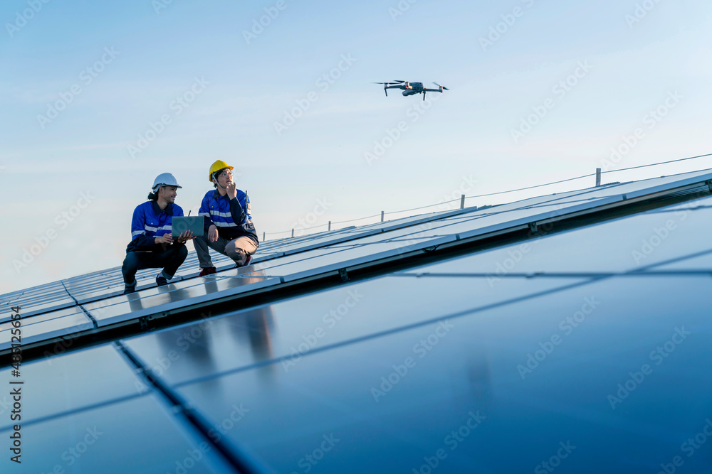 专业技术人员专业工程师控制无人机检查安装太阳能屋顶的俯视图