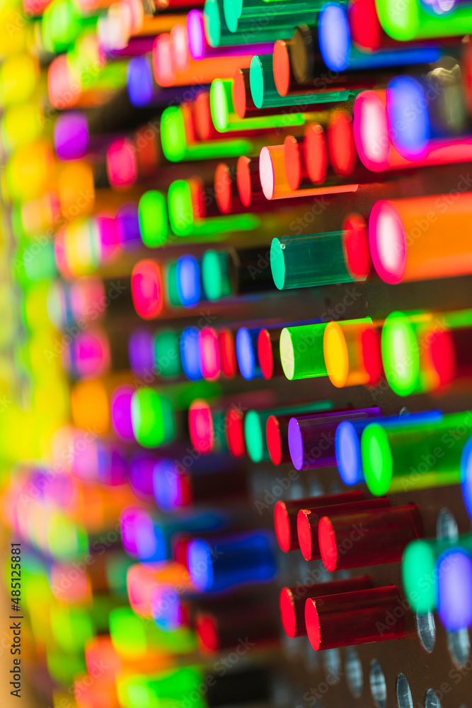 塑料管霓虹灯彩色墙背景，抽象的彩色亚克力圆柱体形式，带有光线