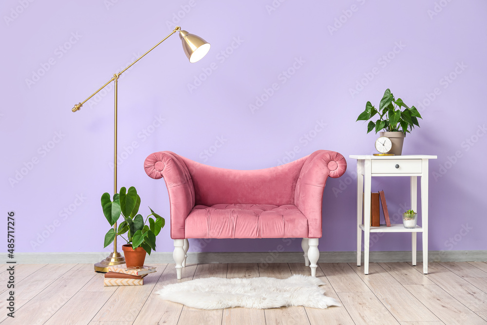 时尚客厅内部，配有粉色扶手椅、台灯和桌子