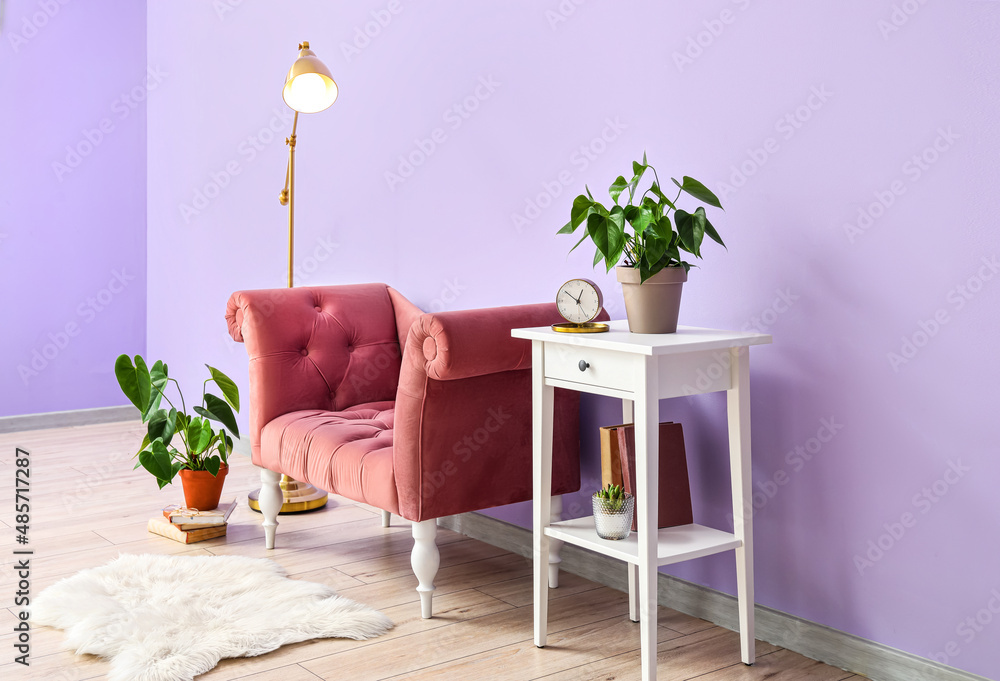 Interior of stylish living room with pink armchair, standing lamp and table