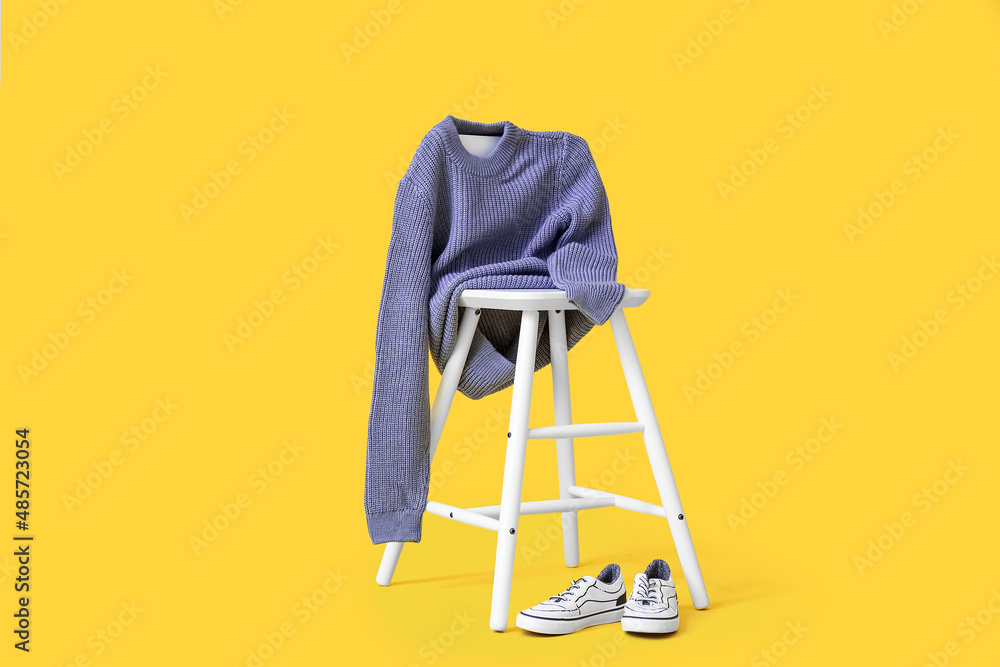儿童针织毛衣和彩色背景鞋的椅子