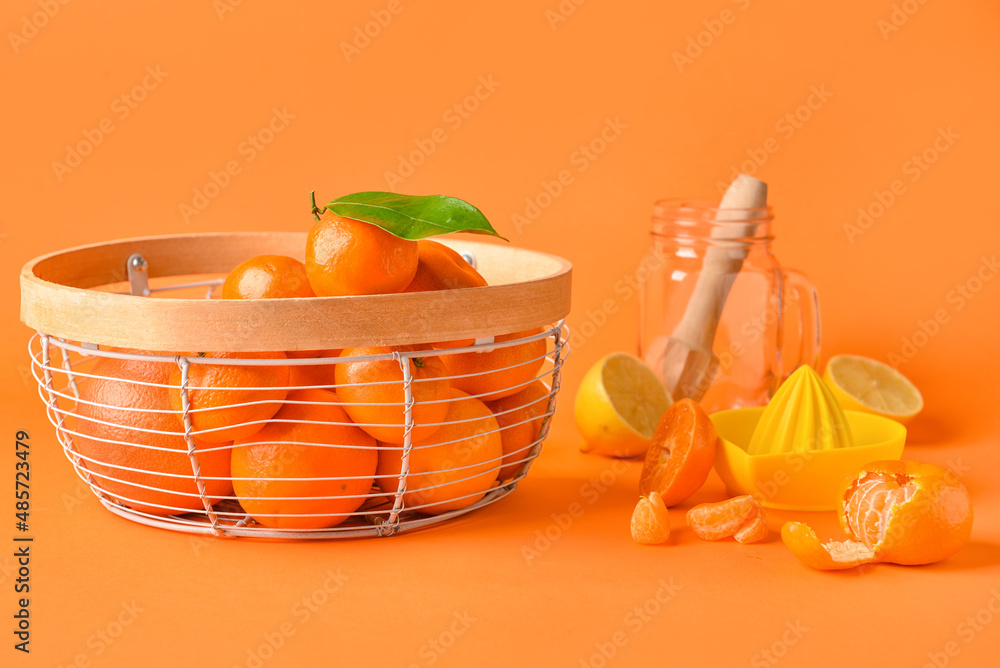 篮子里有新鲜的柑橘类水果和彩色背景的榨汁机