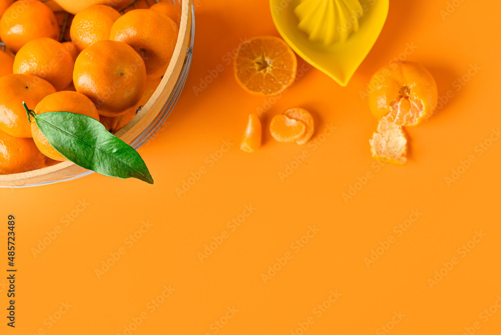 篮子里有新鲜的柑橘类水果和彩色背景的榨汁机