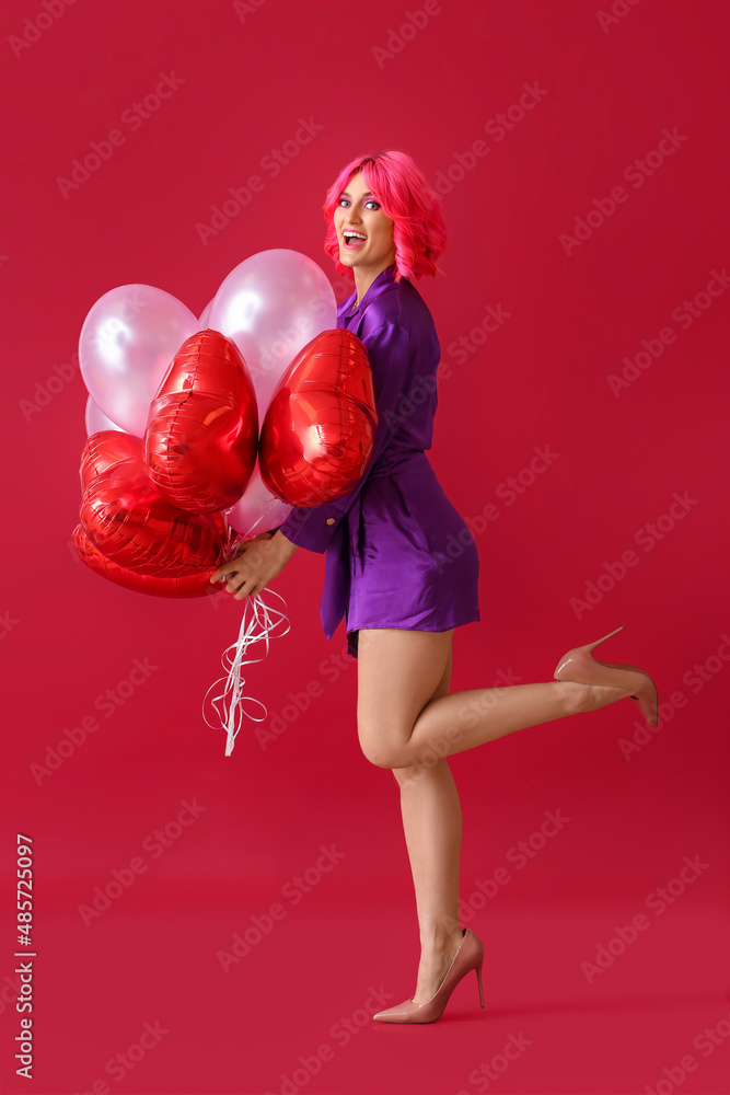 快乐的女人，有着明亮的头发和彩色背景的气球。情人节庆祝活动