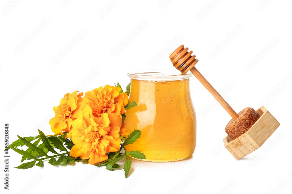 打开的罐子里有蜂蜜、勺子和白底万寿菊花