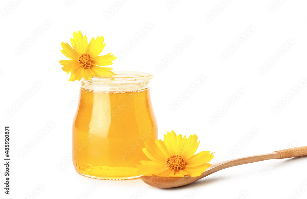 白底蜂蜜、木勺和万寿菊花的罐子