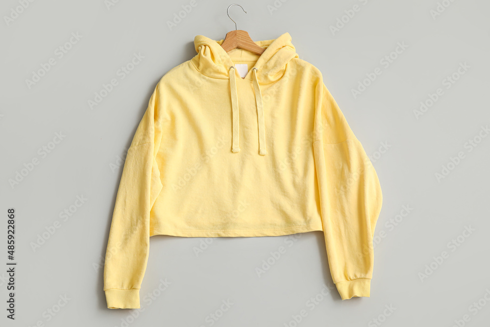 Stylish yellow hoodie on grey background