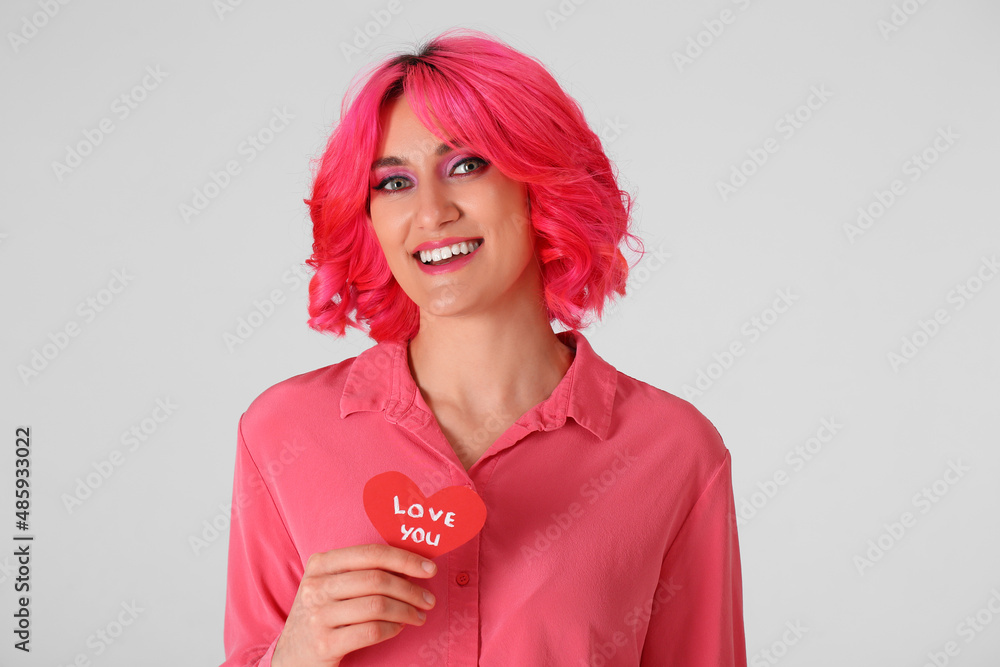 时尚的女人，明亮的头发和红色的心形背景。情人节庆祝活动