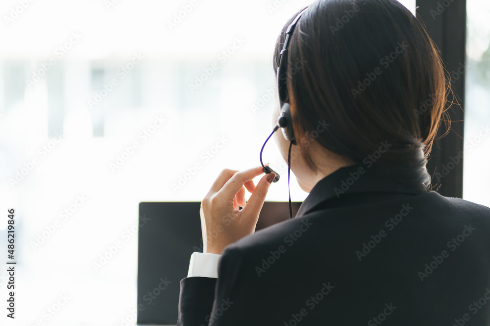 视频c中戴着耳机和笔记本电脑的年轻女商人
