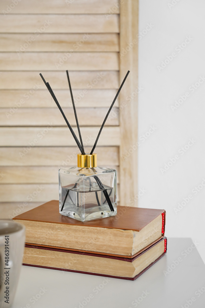 房间桌子上有书的芳香芦苇扩散器
