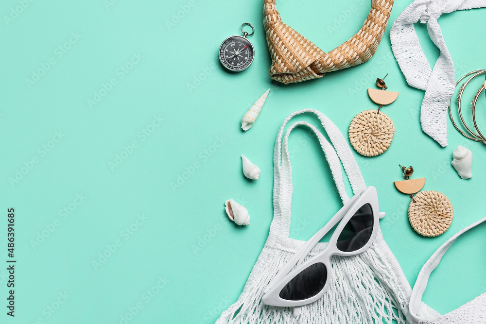 Set of beach accessories with vintage compass on color background