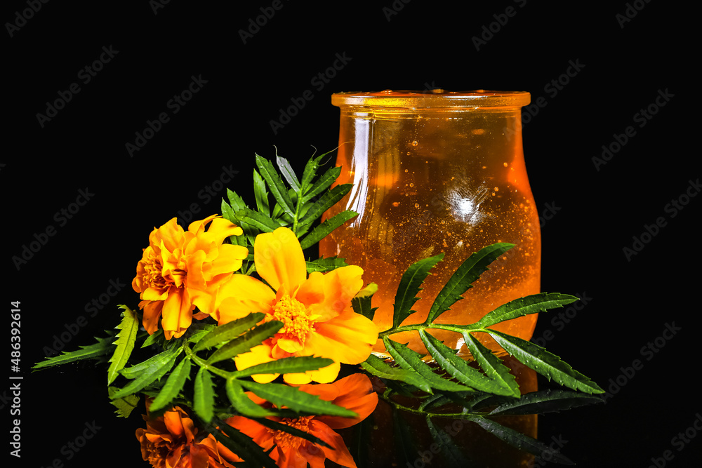 黑底蜂蜜和万寿菊花的罐子