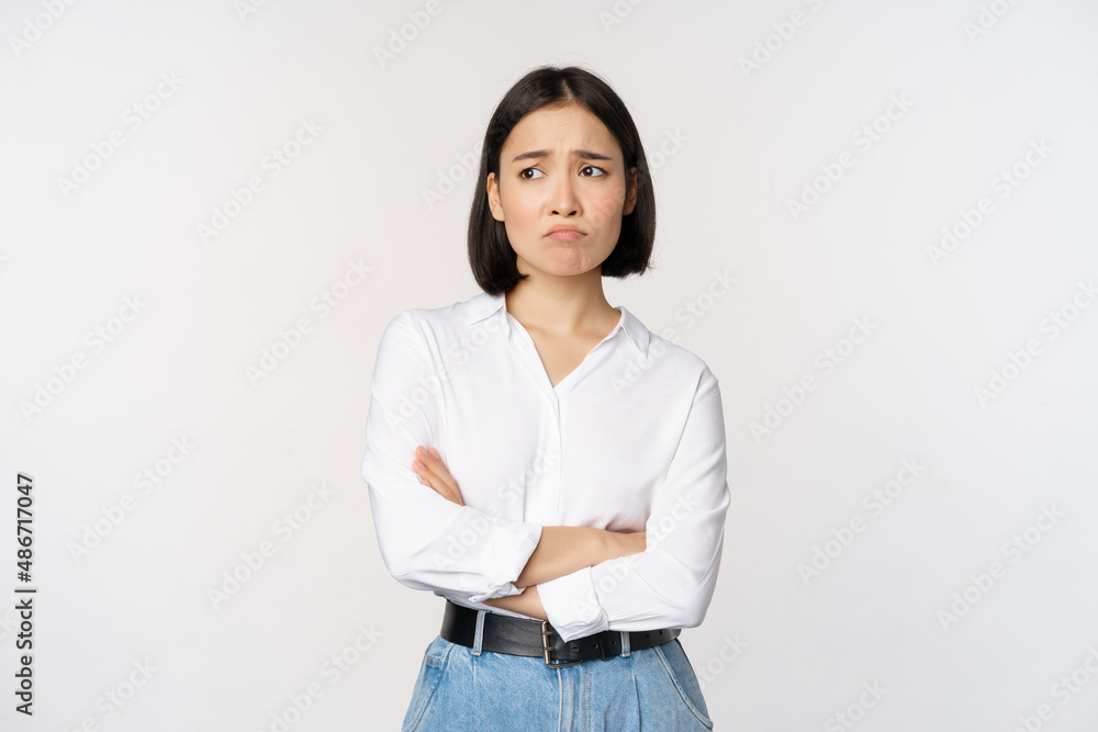 Image of sad office girl, asian woman sulking and frowning disappointed, standing upset and distress
