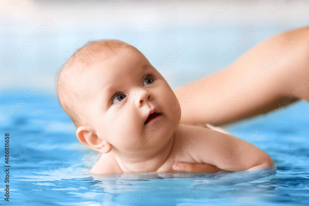 可爱的小婴儿与教练在游泳池合影