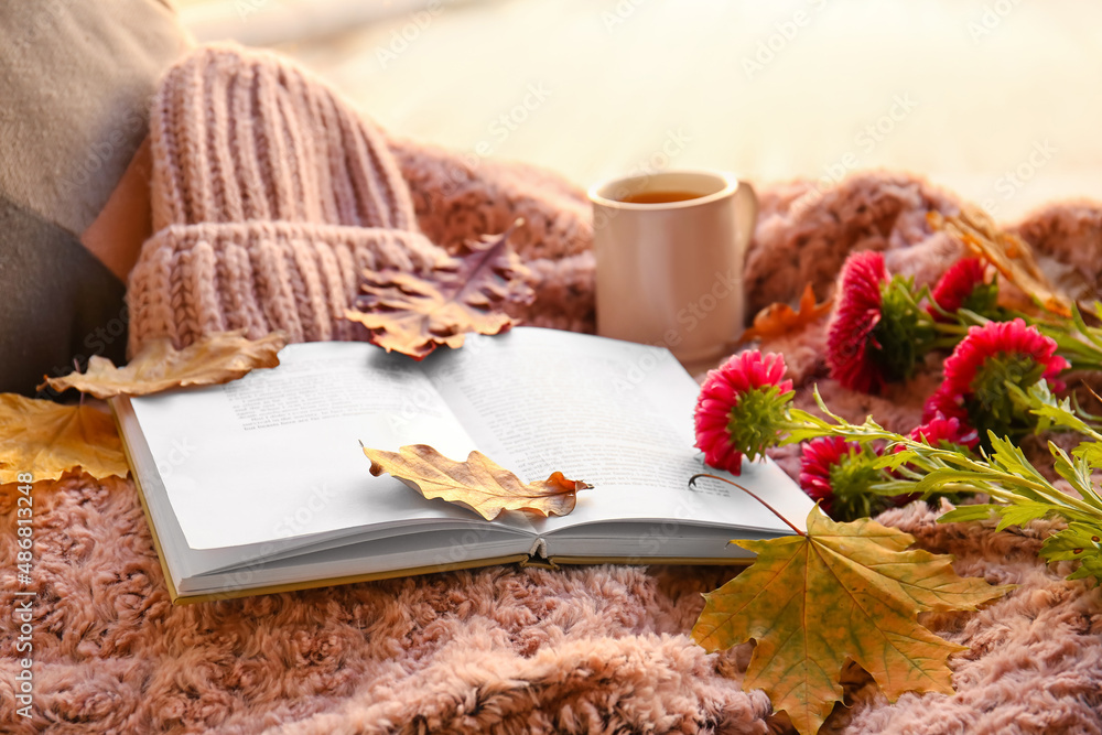 窗台上的书、一杯茶、鲜花和秋季装饰，特写