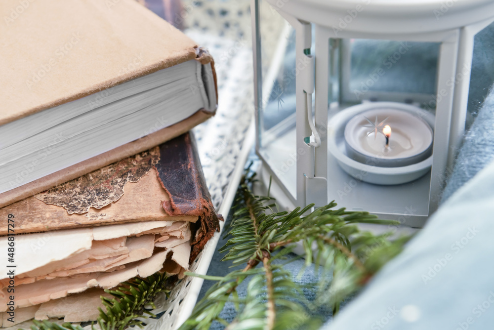 书堆、杉树树枝和带燃烧蜡烛的灯笼，特写