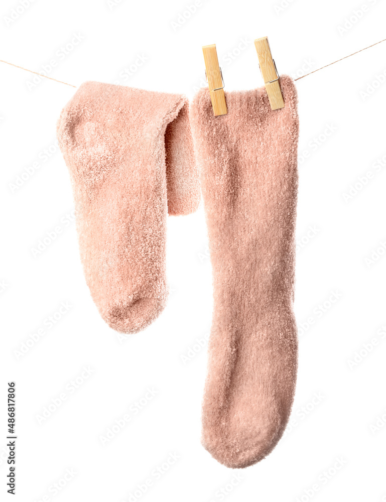 Pair of warm socks hanging on rope against white background, closeup