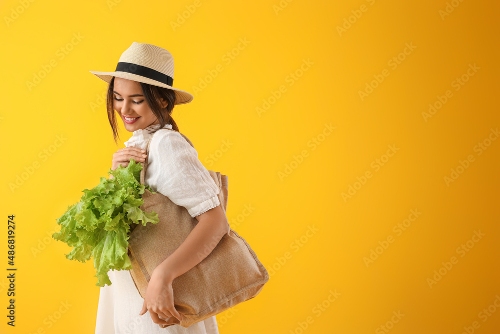 带环保袋和黄底生菜的年轻女子