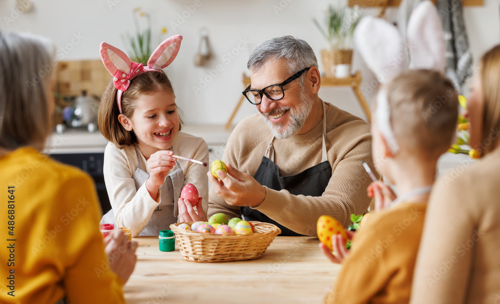 幸福的家庭爷爷和小孙女拿着装满画好的煮鸡蛋的柳条篮子