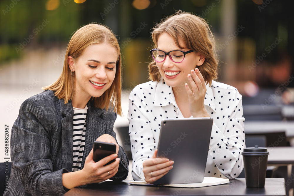 在户外咖啡馆看到数字平板电脑和智能手机时，成功的商业女性兴奋不已