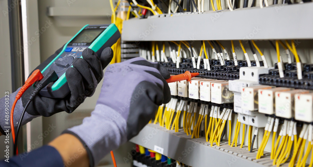 电气工程师测试继电器保护系统上的电气装置和电线。调整