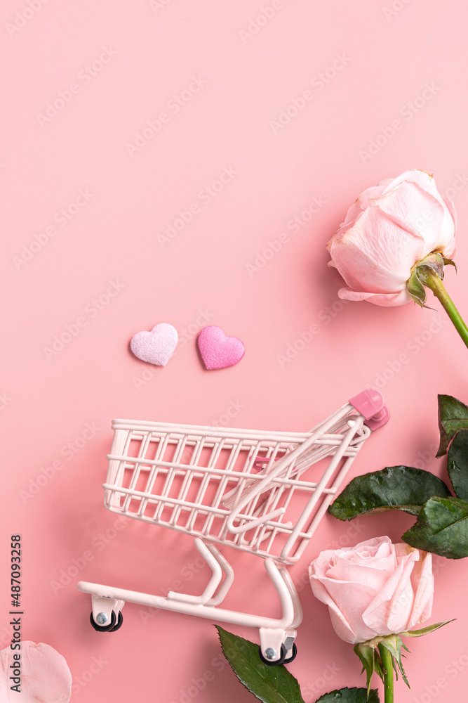 Valentines Day shopping design concept background with pink rose flower and cart on pink background