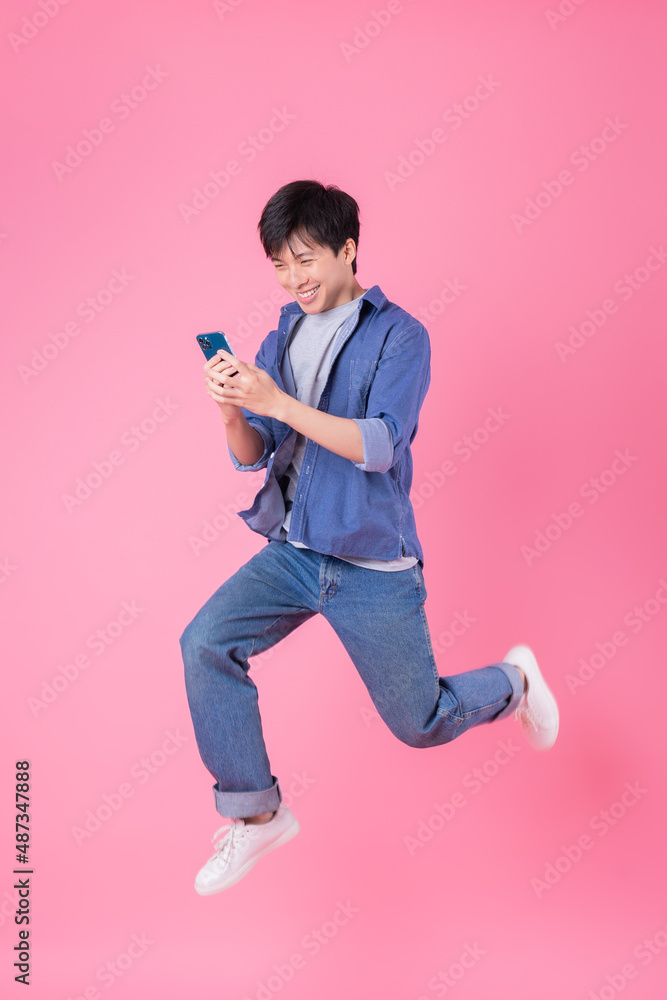 年轻的亚洲男子在蓝色背景上跳跃