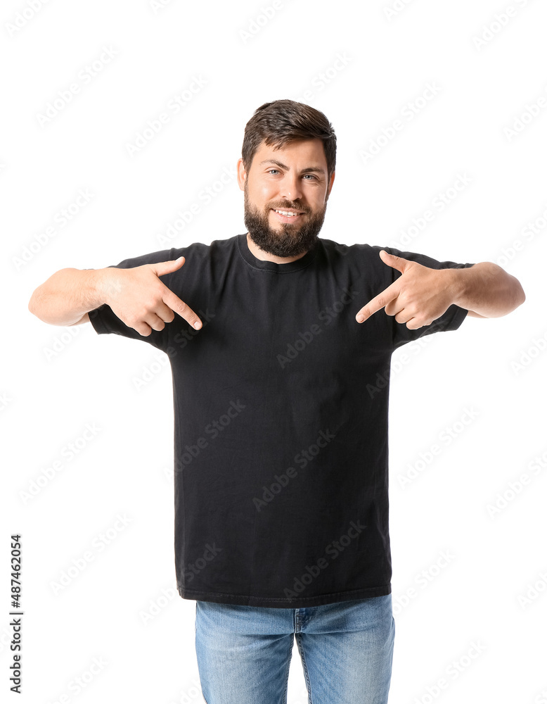 Handsome man pointing at black t-shirt on white background
