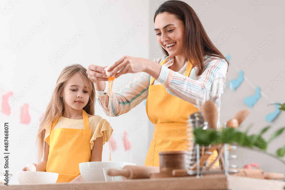 复活节那天，小女孩和妈妈在厨房里打碎鸡蛋