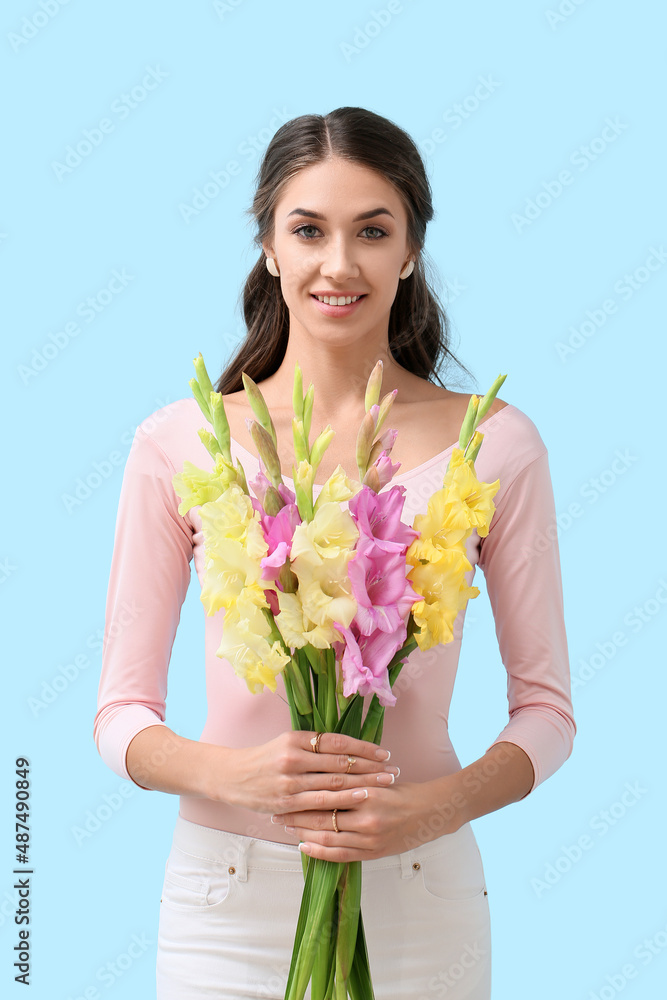 年轻微笑的女人拿着一束彩色背景的唐菖蒲花