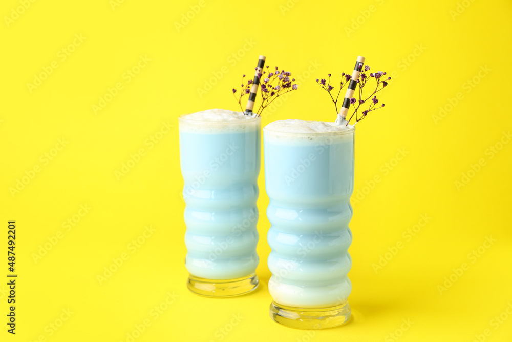一杯蓝色抹茶拿铁和黄色背景的花朵
