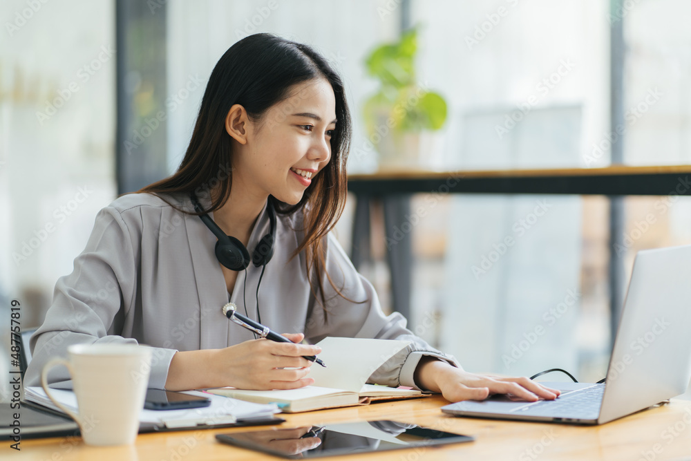 漂亮的年轻自由职业女性坐在咖啡桌旁用笔记本电脑。快乐的微笑女孩Wor