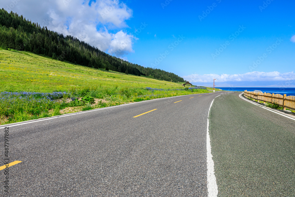 Empty asphalt road and azure ocean nature scenery under blue sky