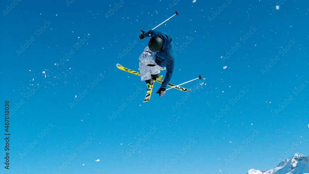 自由式滑雪运动员脱下踢球者，进行一次高难度的360度高空抓地。
