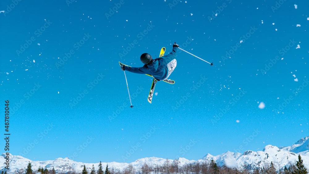 活跃的年轻男性游客在滑雪之旅中表演了令人惊叹的高空技巧。