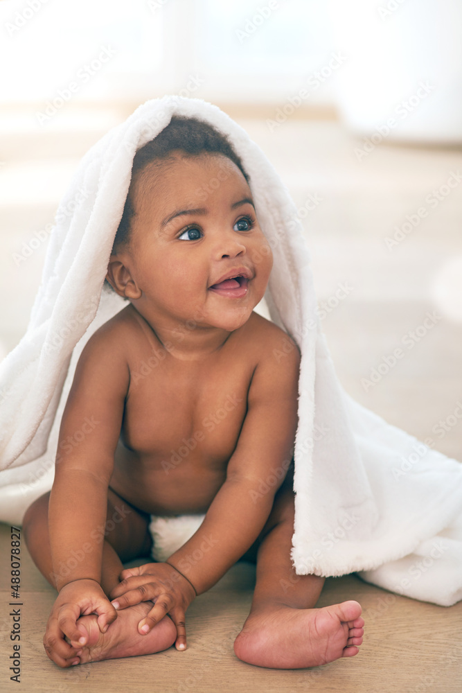 Did someone say bath. Shot of an adorable baby girl covered in a towel at home.