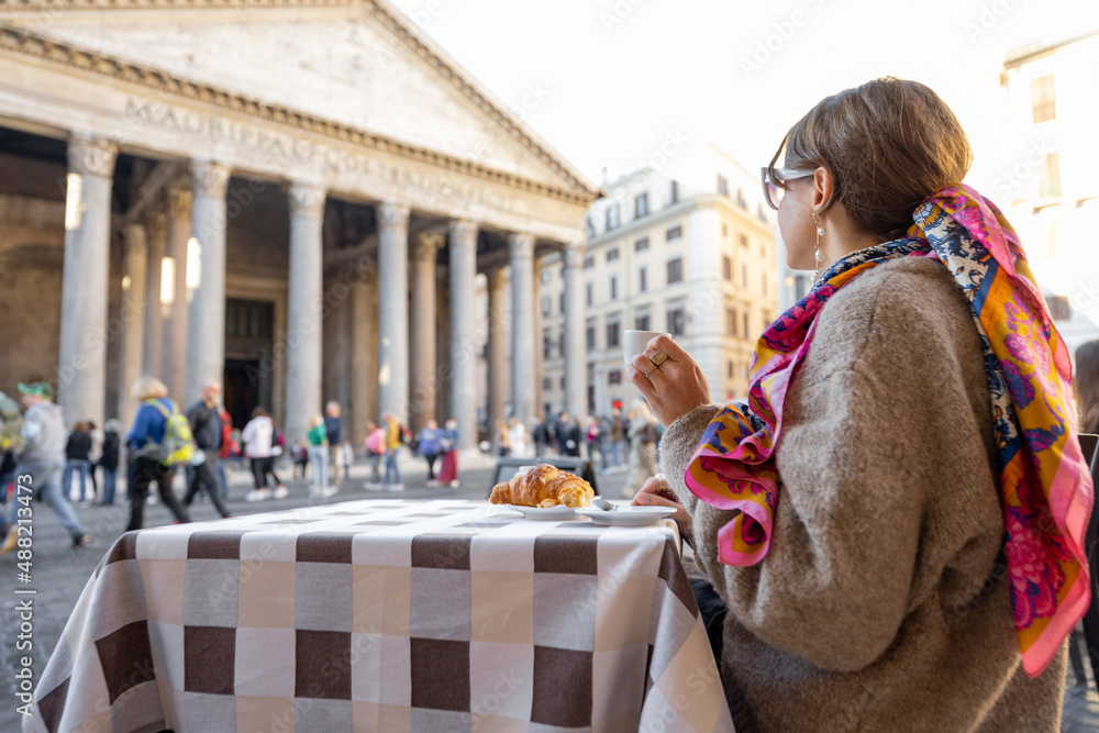 在罗马著名的万神殿附近的户外咖啡馆吃羊角面包和咖啡的女人