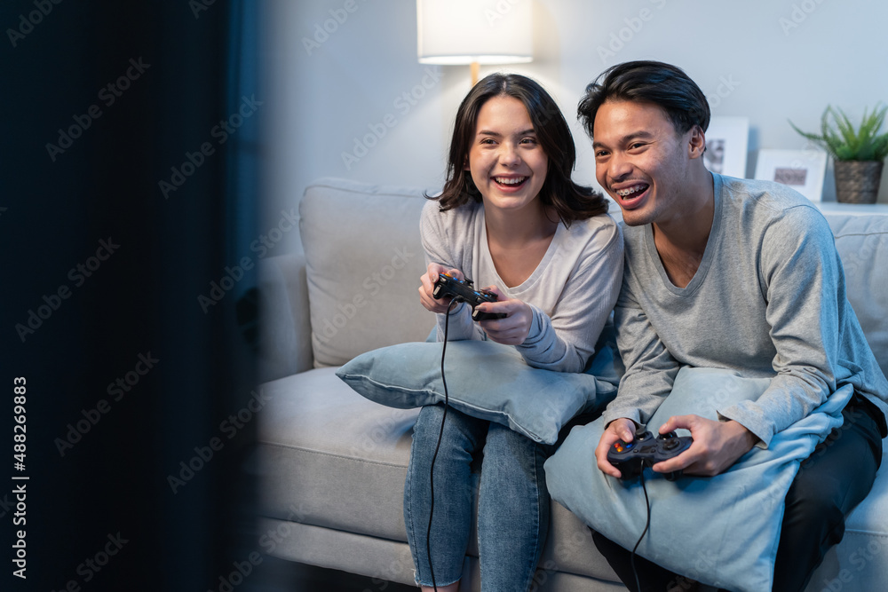亚洲年轻男女夫妇喜欢在家里一起玩游戏。